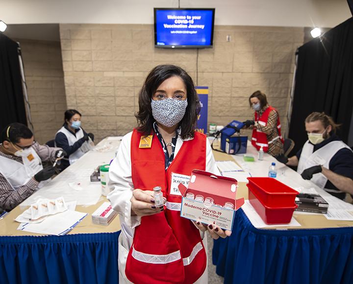 Melissa McGivney holding vials of COVID-19 vaccine at the Petersen Events Center